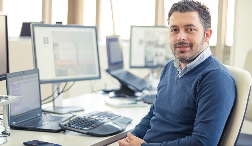 Image of a web design and development student sitting at his computer.