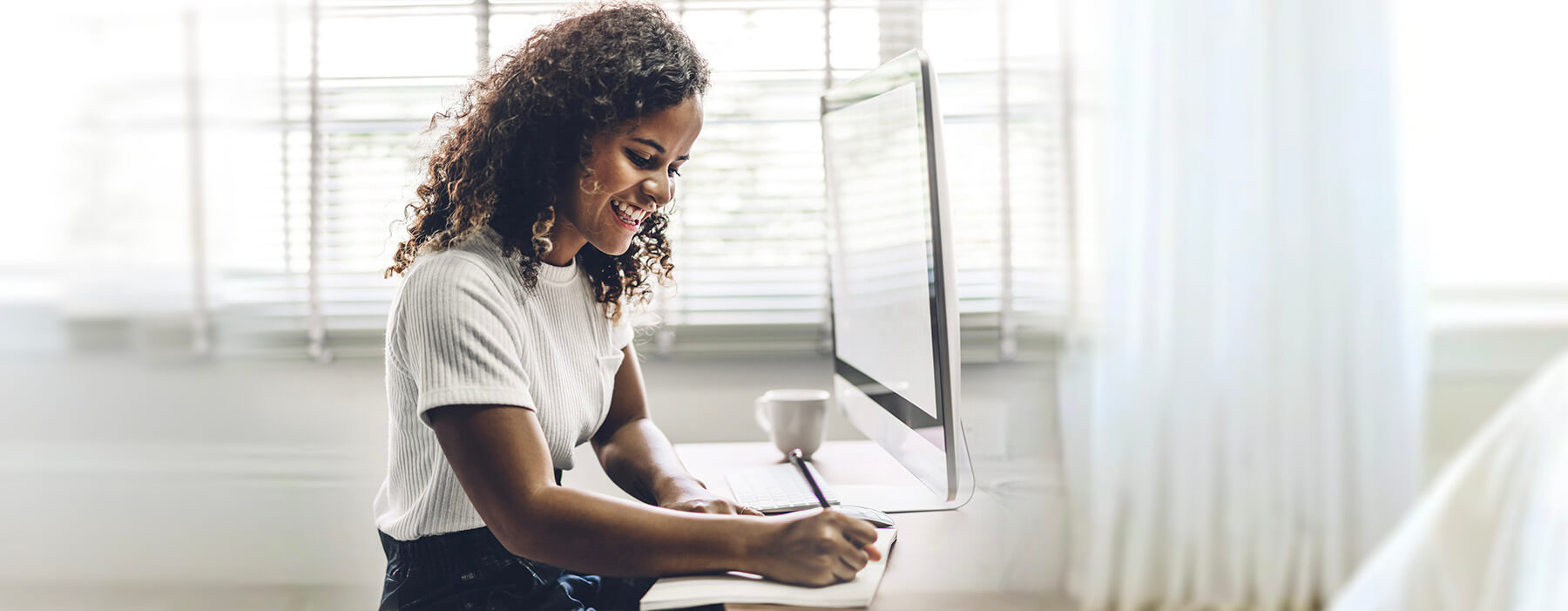 Young woman studying in a bright room at home.