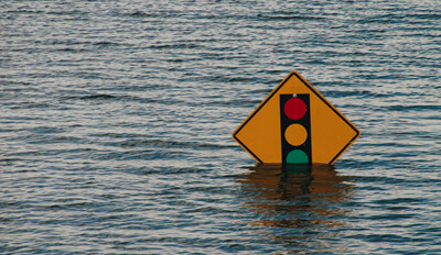 A street sign emerged in water due to a natural disaster.