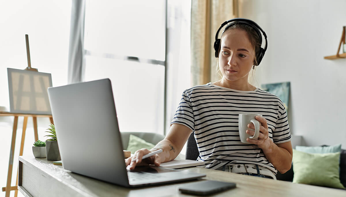 woman creating digital media from home with coffee